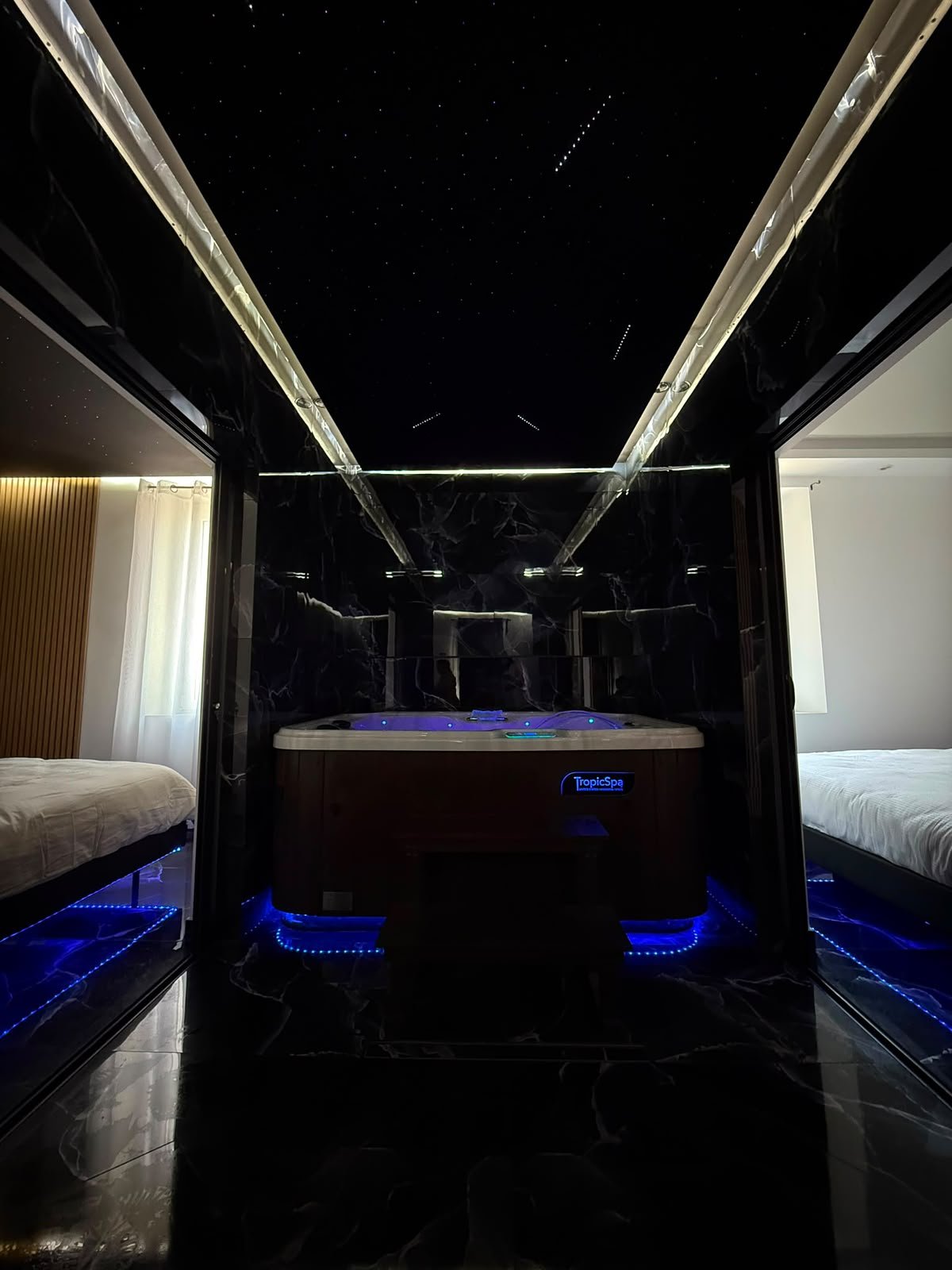 Jacuzzi privatif illuminé entre les deux chambres